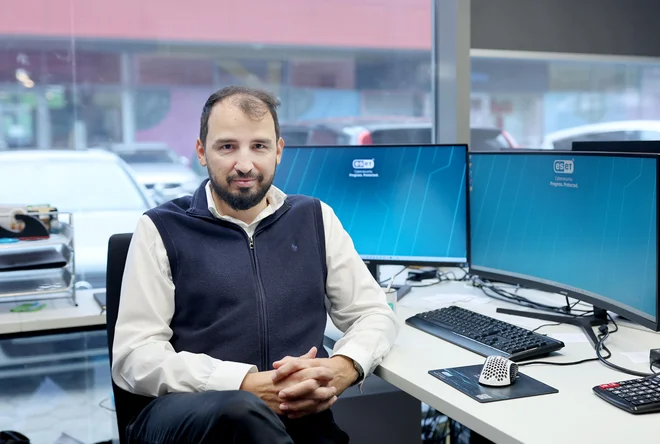 Peter Merc at his desk in front of two monitors.